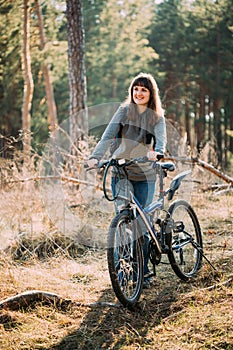 Beautiful Happy Young Woman Smiliing And Standing With Bicycle In Forest In Spring Day