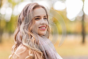 Beautiful happy young woman smiling in autumn park