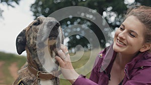 Beautiful Happy Young Woman Stroking her Loving & Loyal Pet Dog in Park