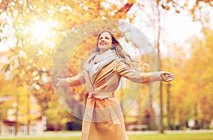 Beautiful happy young woman walking in autumn park