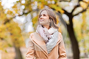 Beautiful happy young woman walking in autumn park