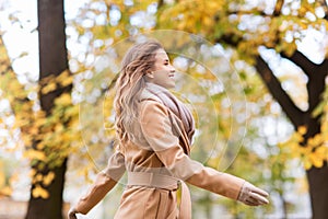 Beautiful happy young woman walking in autumn park