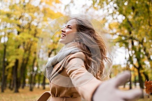 Beautiful happy young woman walking in autumn park