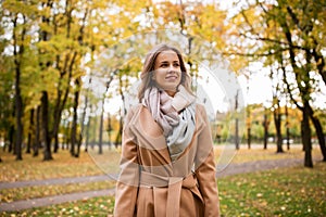 Beautiful happy young woman walking in autumn park