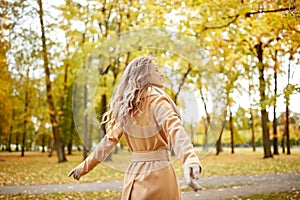 Beautiful happy young woman walking in autumn park