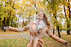 Beautiful happy young woman walking in autumn park