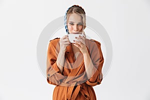 Beautiful happy young woman wearing silk scarf isolated over white background drinking coffee or tea