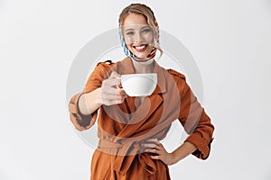 Beautiful happy young woman wearing silk scarf isolated over white background drinking coffee or tea