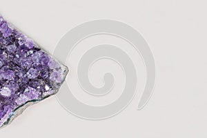 Beautiful healing semiprecious violet amethyst gemstone on white background macro close up with copy space