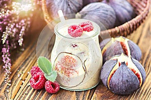 Beautiful healthy appetizer figs fruit smoothie milk shake in glass jar decorated fresh figs pink raspberries top view. Natural d