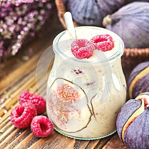 Beautiful healthy appetizer figs fruit smoothie milk shake in glass jar decorated fresh figs pink raspberries top view. Natural d