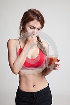 Beautiful healthy Asian girl hate tomato juice.