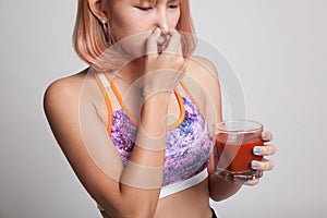 Beautiful healthy Asian girl hate tomato juice.