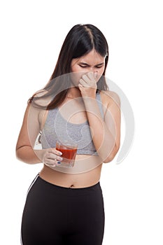 Beautiful healthy Asian girl hate tomato juice.