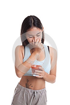 Beautiful healthy Asian girl hate tomato juice.