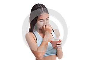 Beautiful healthy Asian girl hate tomato juice.