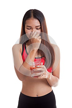 Beautiful healthy Asian girl hate tomato juice.