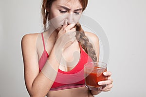 Beautiful healthy Asian girl hate tomato juice.