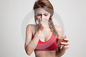 Beautiful healthy Asian girl hate tomato juice.