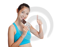 Beautiful healthy Asian girl thumbs up with chocolate
