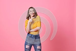 Beautiful healthy young woman smiling with his finger pointing and looking at on light pink banner background with copy space