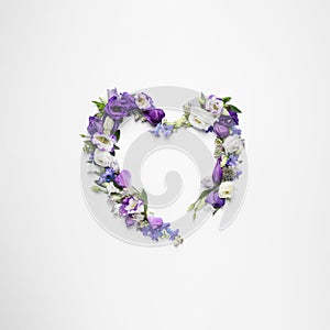 Beautiful heart made of different flowers on white background, top view