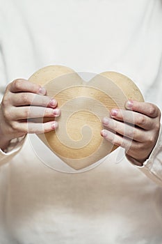 Beautiful heart made of wood in children hands