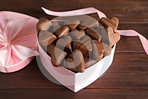 Beautiful heart shaped chocolate candies in box on wooden table