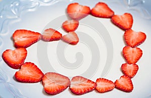 Beautiful heart symbol from chopped red juicy strawberry