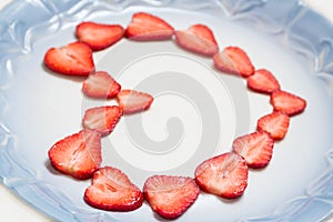 Beautiful heart symbol from chopped red juicy strawberry