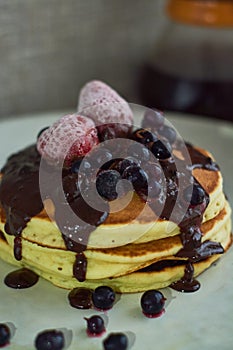 Beautiful hearty breakfast of puncakes with hot chocolate, berries, strawberries and marshmellows.