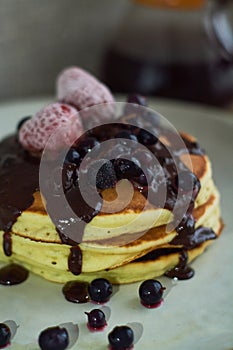 Beautiful hearty breakfast of puncakes with hot chocolate, berries, strawberries and marshmellows.