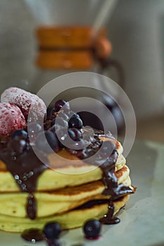 Beautiful hearty breakfast of puncakes with hot chocolate, berries, strawberries and marshmellows.