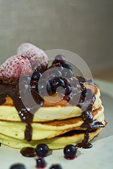 Beautiful hearty breakfast of puncakes with hot chocolate, berries, strawberries and marshmellows.