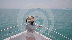 Beautiful high angle back view shot of happy successful tourist woman enjoying amazing sunny sea sail on yacht boat nose