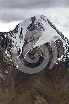 Beautiful high mountain with rocks, snowfields, glaciers and rocky scree photo