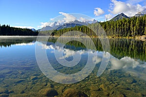 Beautiful high mountains of the Canadian Rockies reflecting in an alpine lake along the Icefields Parkway between Banff and Jasper