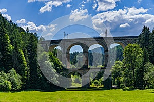 A beautiful high railway viaduct running over a wooded valley