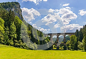 Krásny vysoký železničný viadukt prechádzajúci cez zalesnené údolie