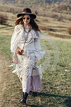 Beautiful hippie girl in hat walking on nature