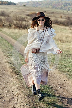 Beautiful hippie girl in hat walking on nature