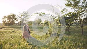 Beautiful hippie woman with dreadlocks in the woods at sunset having good time outdoors