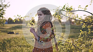 Beautiful hippie woman with dreadlocks in the woods at sunset having good time outdoors