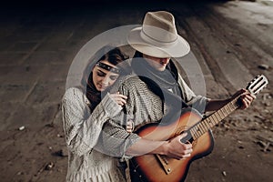 Beautiful hipster couple, handsome cowboy man guitar musician an