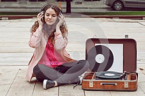 Beautiful hipster girl with old vintage vinyl records. Listen to music with emotions