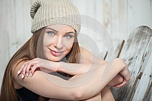 Beautiful hipster woman is sitting near white wall