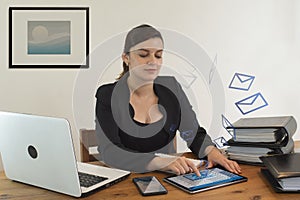 Beautiful Hispanic female executive office worker smiling happy, working sitting at her desk, busy sending emails from her tablet