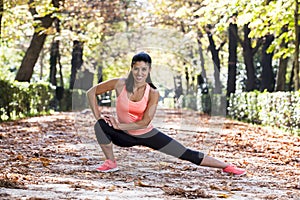 beautiful hispanic sport woman in sportswear stretching body nex