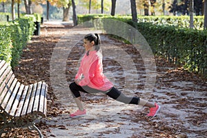 Beautiful hispanic sport woman in sportswear stretching leg on bench doing flexibility exercises warm up before running