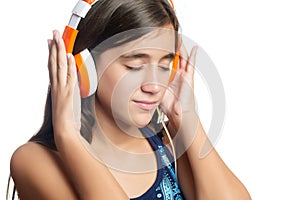 Beautiful hispanic teenage girl enjoying music on bright orange headphones